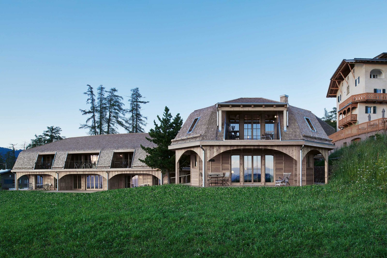 Aus Wald gemacht: Michele De Lucchi liess die Häuser in Ständerbauweise errichten. Von der Aussenterrasse bis zur Dachschindel sind die gesamten Gebäude aus Holz gefertigt. Foto: Max Rommel.