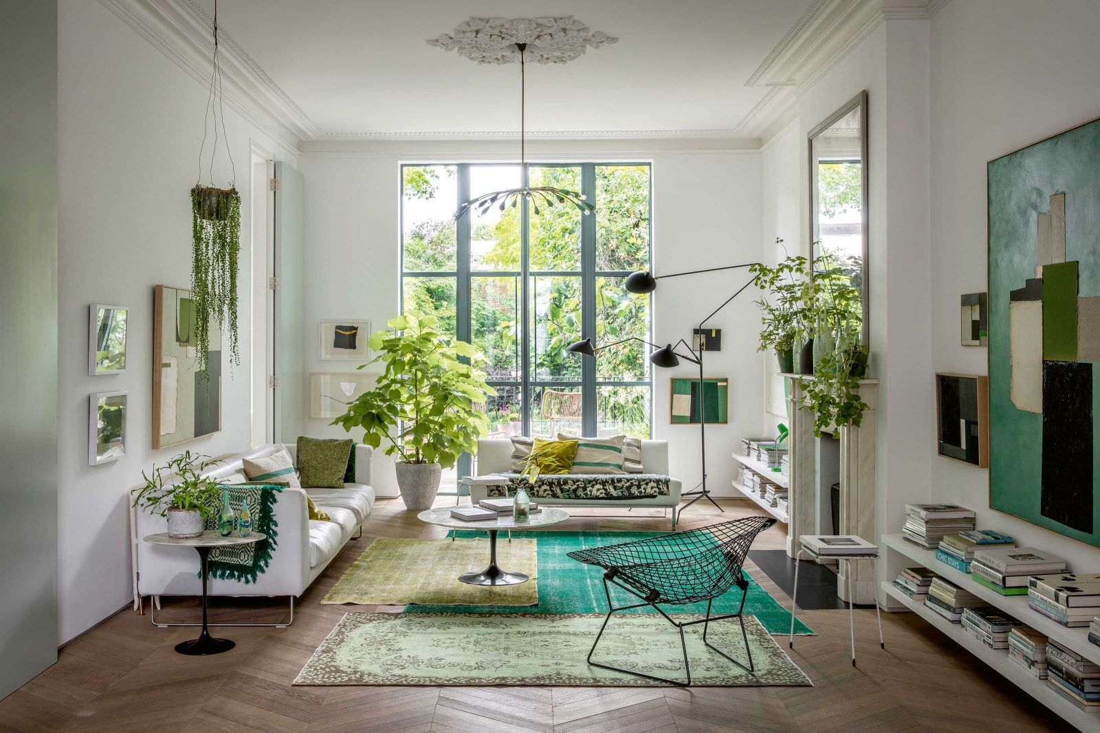 Im Wohnzimmer kombiniert Liza drei ganz unterschiedliche Teppiche von Etsy mit zwei weissen Sofas von Cappellini und Designers Guild. Der Beistelltisch ist von Saarinen, der Stuhl von Bertoia und die Stehleuchte von Serge Mouille.