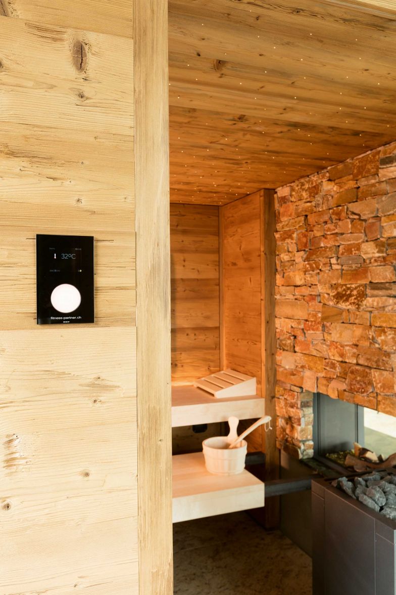 Ihr Kerngeschäft ist der Saunabau – und das seit über 50 Jahren. Individualität und Vielfalt stehen dabei im Vordergrund, wenn es darum geht, Kundenwünsche zu erfüllen. Bei diesem Projekt hier wurde das Cheminée optisch in die Sauna integriert, was in Kombination mit der Steinwand und dem Holz ein echter Blickfang ist. FITPA.CH
