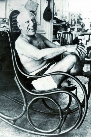 Die gebogenen Holzstühle fanden nicht nur im öffentlichen Bereich Anklang. Hier eine historische Aufnahme von Pablo Picasso in seinem Schaukelstuhl der Gebrüder Thonet.