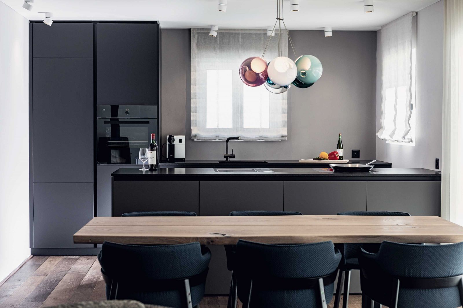 Die passgenau gefertigte Küche zeugt von Stilsicherheit und handwerklichem Können. Eine mundgeblasene Leuchte aus Vancouver spiegelt das Farbspektrum des gesamten Appartements wider.