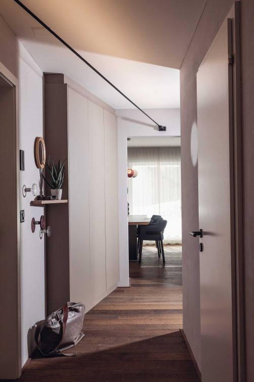 Die Lösung: Eine neue Raumaufteilung mit Schränken, die den Wandschrägen folgen, durchgängigem Eichenparkett, hohen Spiegeln und einer idealen Beleuchtung.