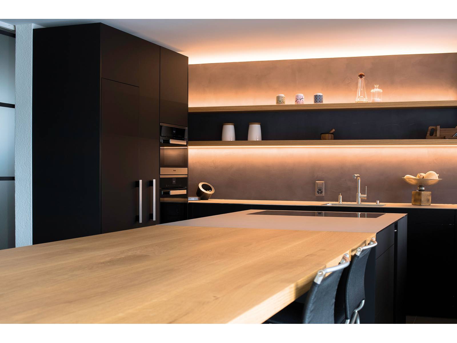 Holz, Rohmetall und Edelstahl sind die Hauptelemente für diese Küche. Stimmige Lichteffekte sorgen für eine wohnliche Atmosphäre, was durch gekonnt platzierte Küchen- und Wohnaccessoires noch unterstrichen wird. Oesch Innenausbau.