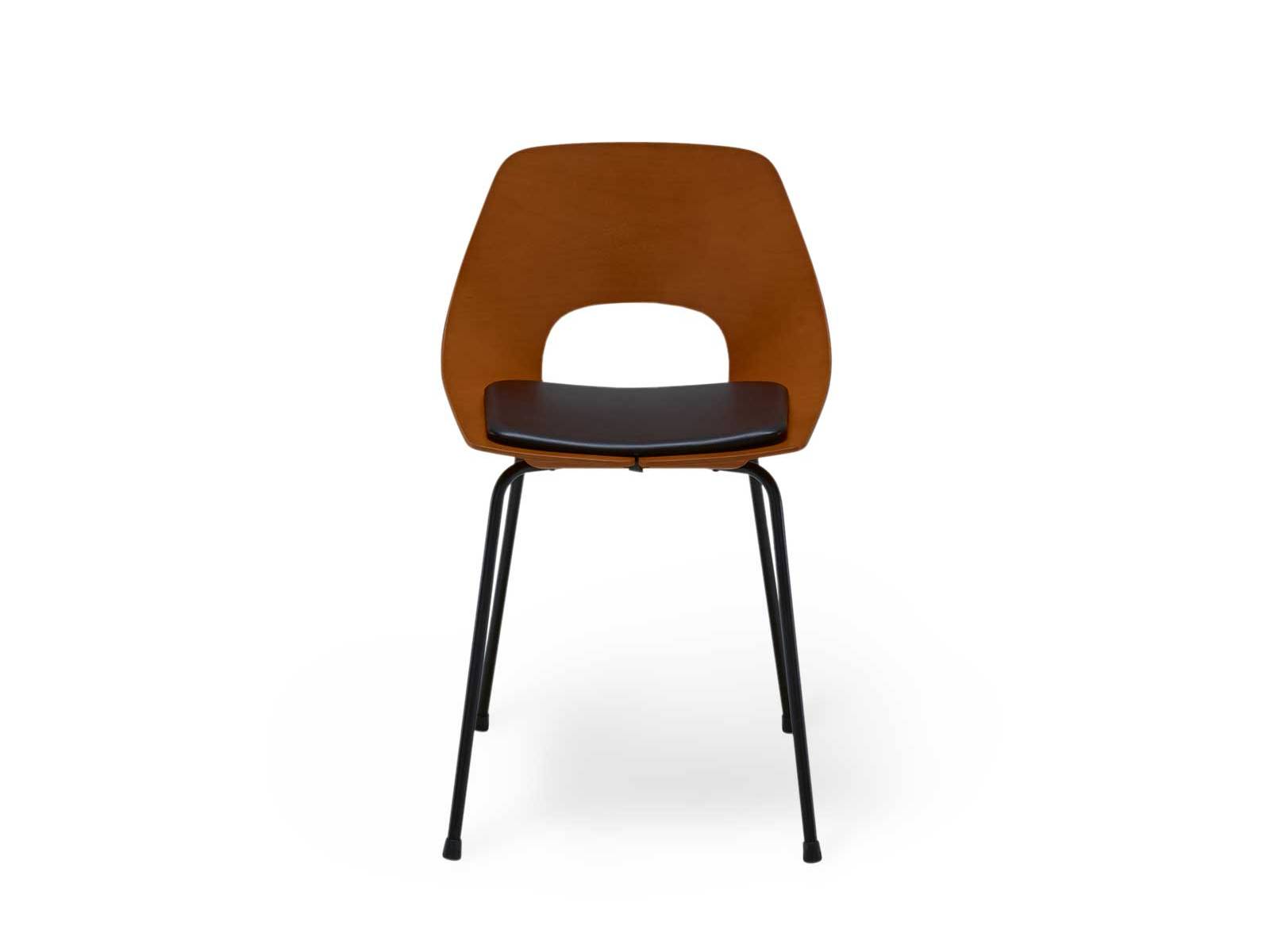 «Chaise Tonneau» gehört zur «Guariche»-Kollektion von Ligne Roset und zeigt die geformte Schichtholzschale von 1954 mit schwarz lackiertem Stahlgestell und schwarzem Lederkissen in neuer Auflage. LIGNE ROSET.