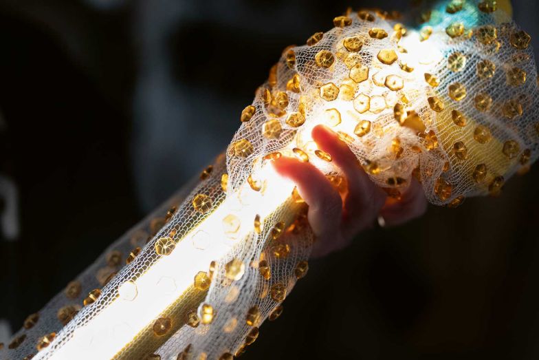 Die mit glänzenden Perlen versetzten Stricktexilien können nach Lust und Laune um die Leuchte drapiert werden – ein sinnliches Erlebnis.