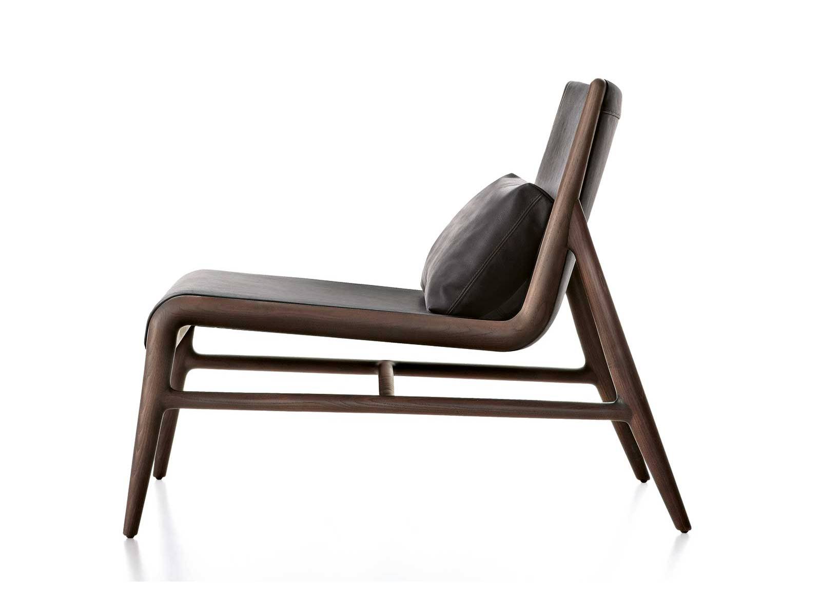 Die Holzstruktur von «Sinua» rahmt Sitz und Rückenlehne präzise ein. Feine Handwerkskunst verbindet sich mit einem gepolsterten Rückenkissen zu einem klaren Design voller Eleganz und Komfort. RIMADESIO.